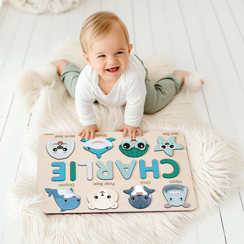 May include: A wooden puzzle with colorful animal illustrations and the name "CHARLIE" spelled out in large letters. The puzzle is on a white fluffy rug and a baby is playing with it.