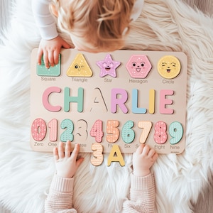 May include: A wooden puzzle board with colorful shapes, numbers, and letters. The shapes include a square, triangle, star, hexagon, and circle. The numbers are 0 through 9. The letters spell out the name "CHARLIE".