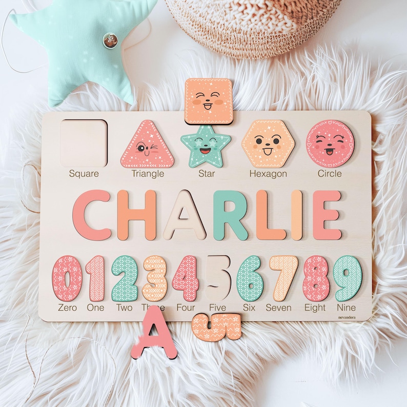 May include: A wooden educational toy with a pastel colour scheme. The toy features a name puzzle, a shape puzzle, and a number puzzle. The name puzzle spells out the name "CHARLIE". The shape puzzle includes a square, triangle, star, hexagon, and circle. The number puzzle includes the numbers 0 through 9.