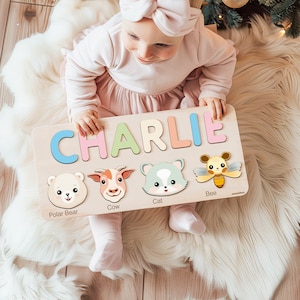 Peut inclure: Un puzzle en bois avec le nom "CHARLIE" &eacute;crit en lettres color&eacute;es. Le puzzle pr&eacute;sente &eacute;galement des images d'un ours polaire, d'une vache, d'un chat et d'une abeille, avec leurs noms imprim&eacute;s sous chaque image.