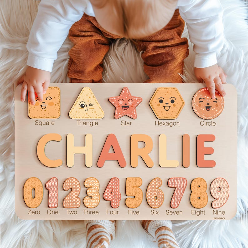 May include: A wooden educational toy with a light brown background. The toy features a variety of shapes, including a square, triangle, star, hexagon, and circle. Each shape has a smiling face and is labelled with its name. The toy also includes the name "CHARLIE" in large, colourful letters and the numbers 0 through 9 with a patterned design.