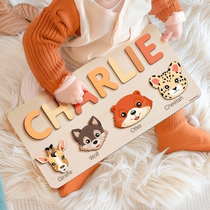May include: A wooden personalized puzzle with the name Charlie spelled out in colorful letters. The puzzle also features five animal illustrations: a giraffe, wolf, otter, cheetah, and a cheetah.