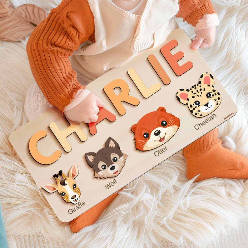 May include: A wooden personalized puzzle with the name Charlie spelled out in colorful letters. The puzzle also features five animal illustrations: a giraffe, wolf, otter, cheetah, and a cheetah.