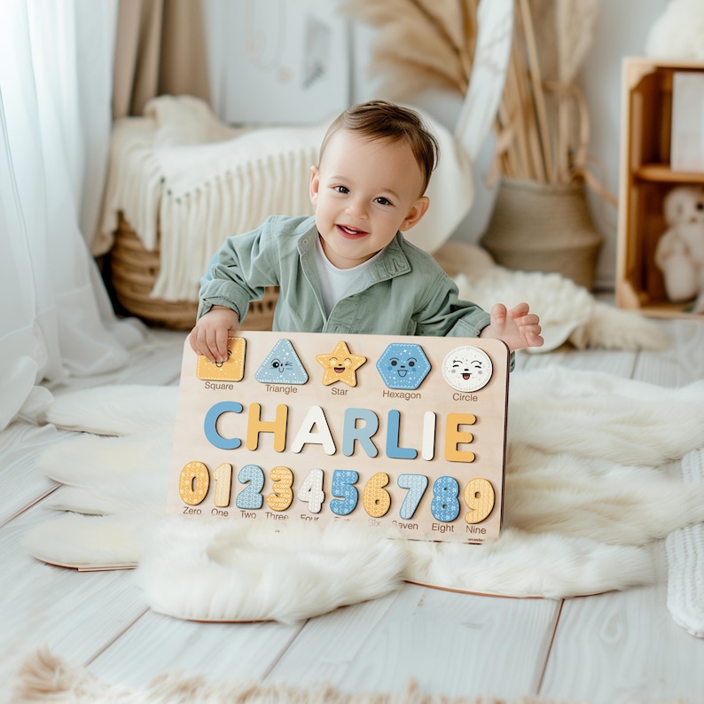May include: A wooden educational toy with a child's name "CHARLIE" spelled out in colourful letters. The toy also features numbers 0-9, geometric shapes, and the names of each shape.