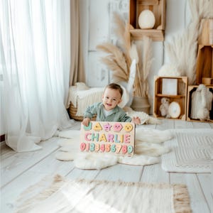 May include: A wooden puzzle with the name "CHARLIE" and numbers 0-9 in various colors. The puzzle has colorful shapes and is held by a smiling child. The background includes wooden crates and decorative elements.