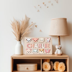 Peut inclure: Un puzzle en bois avec des visages d'animaux et le nom Charlie. Le puzzle est sur une &eacute;tag&egrave;re avec un vase de pampas s&eacute;ch&eacute;es et une lampe.