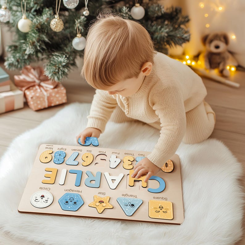 May include: A wooden puzzle with the name "CHARLIE" and numbers 1-9. The puzzle also includes shapes like a circle, hexagon, star, triangle, and square. The child is playing with the puzzle on a white fluffy rug.