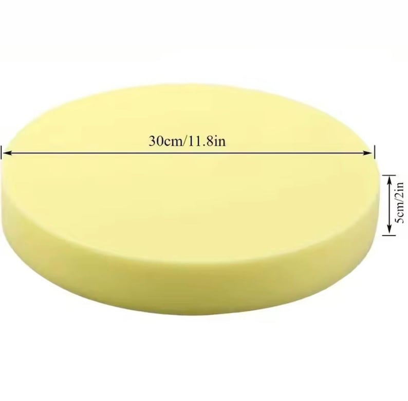 May include: A round, pale yellow object, 30cm (11.8in) in diameter and 5cm (2in) thick. The object has a smooth surface and a cylindrical shape. The image is taken from a slightly elevated angle, showing the entire object.
