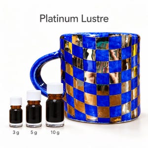 May include: A ceramic mug with a blue and gold checkered pattern, labeled Platinum Lustre, accompanied by three small amber glass bottles with white caps, labeled 3 g, 5 g, and 10 g, representing the contents for the mug.