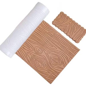 May include: A set of three wood grain textured baking tools. Includes a white rolling pin, a rectangular brown mat, and a smaller, scalloped-edge brown piece. The tools are designed to imprint a wood grain pattern on various surfaces.