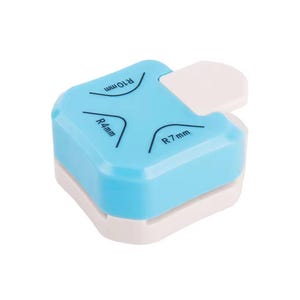 May include: A light blue and white corner rounder tool. The tool has a white lever and markings for R4mm, R7mm, and R10mm corner radii. The tool is designed to round the corners of paper or cardstock.