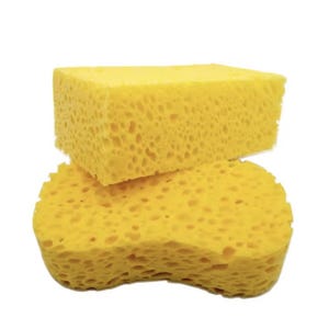 May include: Two yellow sponges with a porous, textured surface. The top sponge is rectangular with sharp edges, while the bottom sponge has a contoured, ergonomic shape with curved sides. Both items feature a consistent bright yellow colour.
