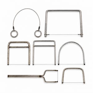 May include: A collection of seven metal wire cutters and saws for clay or food. The set includes a flexible wire with ring handles, a large rectangular frame saw, three smaller rectangular frame saws, a curved arch saw, and a long-handled tool.