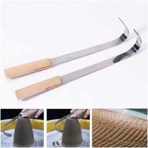 May include: Two pottery trimming tools featuring long, curved, silver-colored metal blades attached to cylindrical light-colored wooden handles. These tools are designed for shaping clay on a pottery wheel, as shown in the accompanying images.