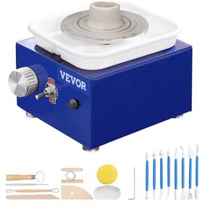 May include: A blue VEVOR pottery wheel with a white basin and a centered clay cylinder on the wheel head. The control panel features a silver speed knob and an on-off toggle switch. Included are various wooden and metal sculpting tools and a sponge.