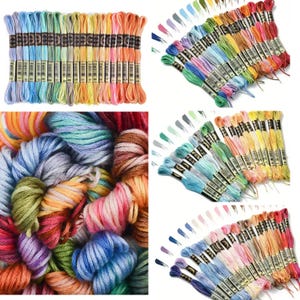 Peut inclure: Un assortiment de fils à broder colorés dans diverses nuances, notamment des bleus, des verts, des jaunes, des oranges et des roses. Les fils sont soigneusement organisés en paquets, certains disposés en éventail, d'autres en tas.