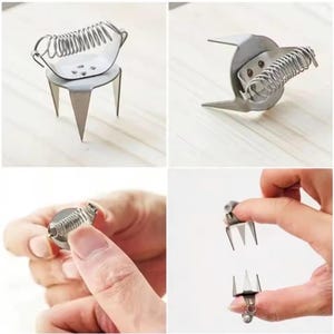 May include: A silver-colored stainless steel thumb knife tool featuring a sharp, pointed blade and a coiled spring mechanism designed to fit securely over the thumb for harvesting or cutting tasks in a garden or kitchen setting.