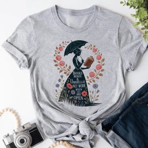 a t - shirt with a picture of a woman holding an umbrella