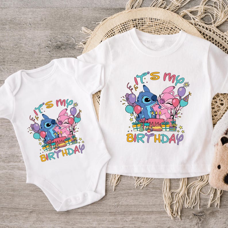 two baby onesuits sitting next to a teddy bear