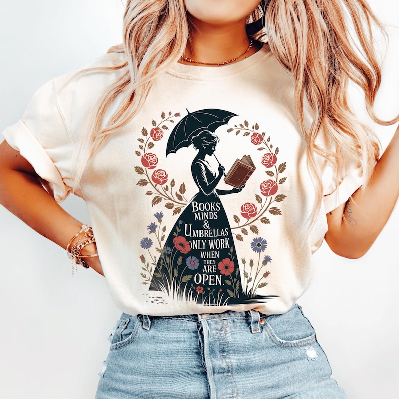 a woman wearing a t - shirt with a picture of a woman holding an umbrella