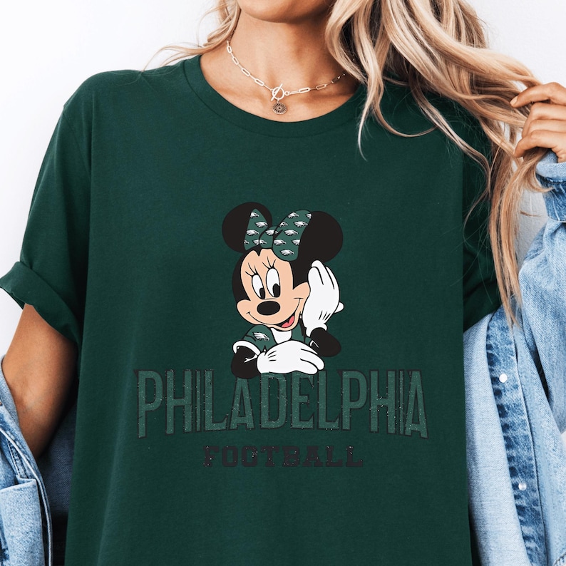 A green t-shirt with a Minnie Mouse graphic and the text "PHILADELPHIA FOOTBALL" printed on it.