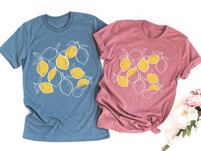 two t - shirts with lemons on them next to a bouquet of flowers
