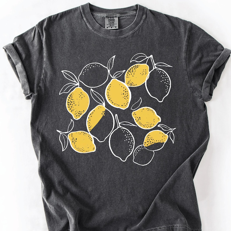 a black t - shirt with lemons on it