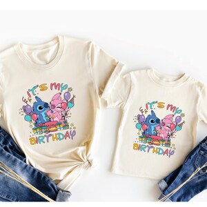 a couple of t - shirts that are on top of a pair of jeans