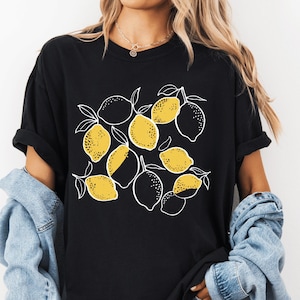 a woman wearing a black shirt with lemons on it