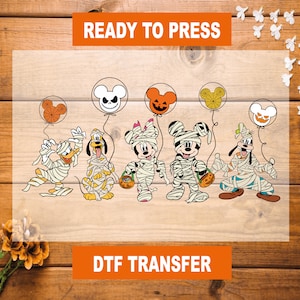 May include: A Halloween-themed iron-on transfer featuring Mickey Mouse and friends dressed as mummies. The design includes Mickey Mouse, Minnie Mouse, Donald Duck, Goofy, and Pluto. Each character is holding a pumpkin or candy. The transfer is ready to press and is perfect for creating custom apparel or accessories.