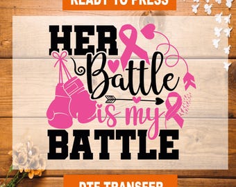 May include: A DTF transfer design with the text "HER Battle is my BATTLE" in black and pink. The design includes pink boxing gloves, ribbons, hearts, and an arrow. The words "READY TO PRESS" and "DTF TRANSFER" are also present.