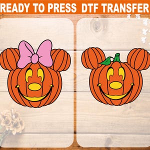 May include: Two orange pumpkin-shaped designs with Mickey Mouse ears and smiling faces. One has a pink bow, the other a green stem. The text "READY TO PRESS DTF TRANSFER" is at the top.