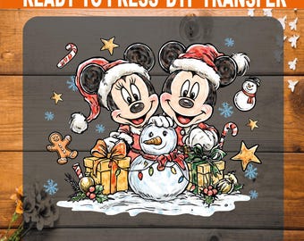 May include: A DTF transfer featuring Mickey and Minnie Mouse in Santa hats, with a snowman, gifts, and Christmas decorations. The text "READY TO PRESS DTF TRANSFER" is at the top. The image has a festive, holiday theme.