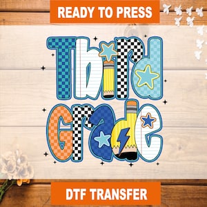 May include: A colorful DTF transfer design for third grade. The design features the words "Third Grade" in a playful font, with checkered, lined paper, and star accents. The words are in blue, orange, and white, with yellow pencils.
