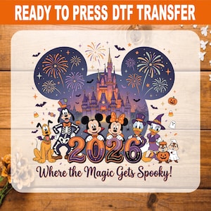 May include: A ready to press DTF transfer featuring a Halloween-themed graphic with Mickey Mouse, Minnie Mouse, Goofy, Donald Duck, Daisy Duck, Pluto, and Chip and Dale in costumes. The design includes a castle, fireworks, and the text 2026 Where the Magic Gets Spooky!