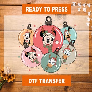 May include: DTF transfer featuring six Christmas ornament designs with Disney characters Mickey Mouse, Minnie Mouse, Goofy, Pluto, and Donald Duck. Each character is wearing a Santa hat and scarf. The text "READY TO PRESS" and "DTF TRANSFER" are displayed.