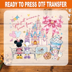 May include: A DTF transfer sheet featuring a castle, a large pink bow with mouse ears, a cup with whipped cream, a cookie, and two cartoon characters sitting on a bench. The text reads Girl just wanna have fun and Let the Magic Begin.