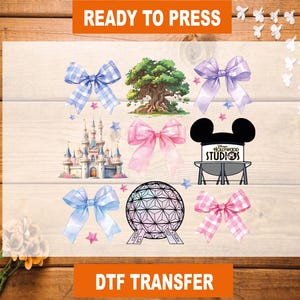 May include: A set of eight iron-on transfers featuring Disney-themed designs. The designs include a pink bow, a blue bow, a pink and white checkered bow, a tree, a castle, a Mickey Mouse head, a Hollywood Studios sign, and a Spaceship Earth globe.