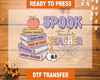 May include: A DTF transfer sheet featuring a stack of five books with titles Spooky Teacher, Hocus Focus, Trick or Teach, Halloween, and Witchy Teacher, topped with an apple. Includes a skull with a candle, a spiderweb, and text Spooktacular Teacher.