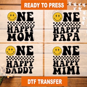 May include: Four DTF transfer sheets with the words "ONE HAPPY MOM", "ONE HAPPY PAPA", "ONE HAPPY DADDY", and "ONE HAPPY MIMI" in black, with a yellow smiley face and a checkered pattern. The text "READY TO PRESS" and "DTF TRANSFER" are also present.