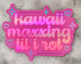May include: A pink sticker with the words "Kawaii maxxing til i rot" in a bubble font. The sticker has a holographic effect and is decorated with hearts and stars.