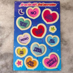 May include: A sticker sheet with a blue background and various heart-shaped stickers. The stickers feature phrases like "NO," "GIRL GANG," "TREAT TIME," and "SELF CARE." The text "far out fun club's feral conversations" is at the top.
