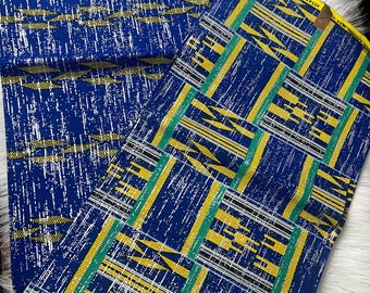 May include: Two pieces of blue and yellow patterned fabric with the text "VÉRITABLE SUPER" and "RICHER TANCET" printed on the fabric.