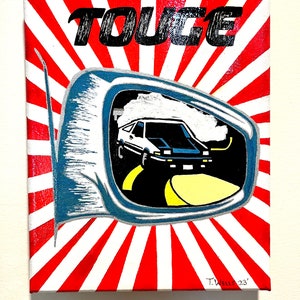 May include: A white car with a red and white sunburst background. The car is reflected in a rearview mirror. The word "Touce" is written in black letters at the top of the image. The artist's signature, "T. Wells 23", is in the bottom right corner.
