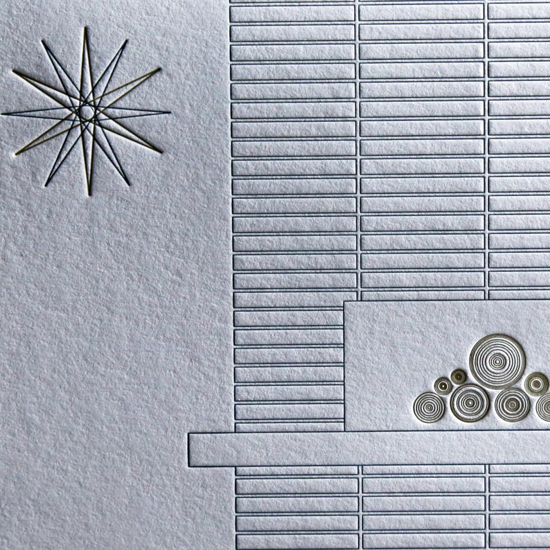 May include: A textured, light gray card with an embossed design. The design includes a starburst, rectangular blocks, and a series of concentric circles. The overall aesthetic is minimalist and geometric.