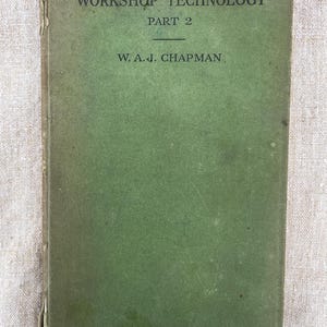 May include: A vintage hardcover book titled Workshop Technology Part 2 by W. A. J. Chapman. The book features a faded olive green cloth cover with black printed text on the front. The spine shows signs of wear and fraying along the edges.
