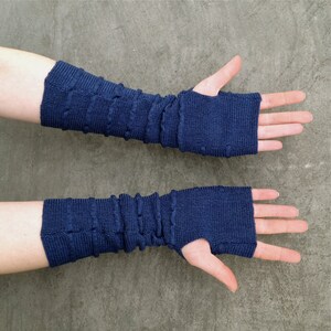 May include: A pair of navy blue fingerless gloves with a textured knit design.