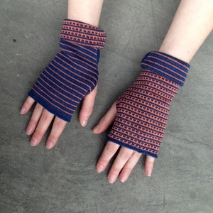 May include: A pair of fingerless gloves with a striped pattern in blue and orange. The gloves are made of a soft, knitted fabric.