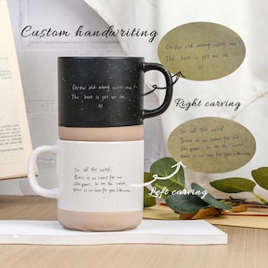 Puede incluir: Dos tazas de cerámica blancas y negras con mensajes escritos a mano personalizados. Las tazas están apiladas una encima de la otra. La taza superior tiene el mensaje "Grow old along with me! The best is yet to be." La taza inferior tiene el mensaje "In all the world, there is no heart for me like yours. In all the world, there is no love for you like mine."
