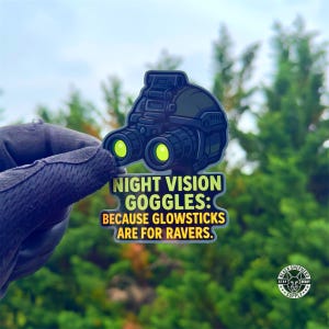 Può includere: Un adesivo con un design di occhiali per la visione notturna in nero e verde. Il testo recita: "NIGHT VISION GOGGLES: BECAUSE GLOWSTICKS ARE FOR RAVERS." È visibile il logo Black Shepherd Supply.